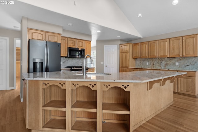 89523 Manion Dr, Warrenton, OR 97146 - kitchen featuring stainless steel appliances, decorative backsplash, light wood-type flooring, vaulted ceiling, and a spacious island