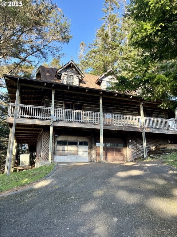 29202 Wallace St, Gold Beach, OR 97444 - view of front of house with an attached garage, aphalt driveway, and a wooden deck