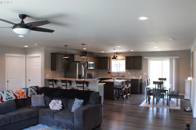 living room with recessed lighting, dark wood-style floors, and a ceiling fan