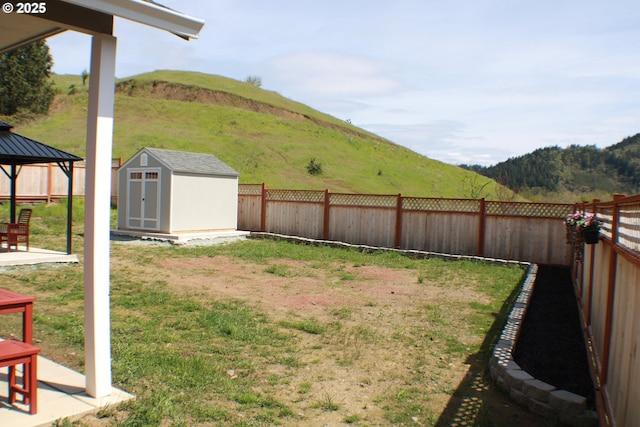 view of yard with a mountain view, a gazebo, an outdoor structure, and a storage unit