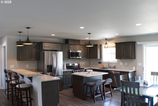 kitchen featuring a kitchen bar, a sink, a wealth of natural light, and stainless steel appliances