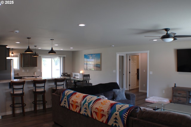living room featuring dark wood-style flooring, baseboards, a ceiling fan, and recessed lighting