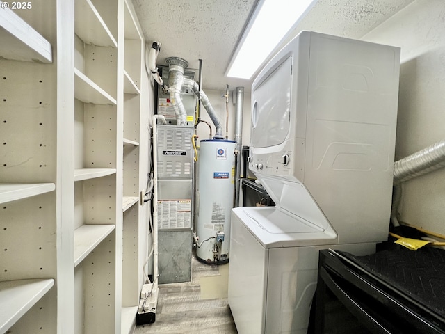 955 SW 10th St, Hermiston, OR 97838 - washroom with gas water heater, stacked washer / dryer, wood finished floors, and a textured ceiling