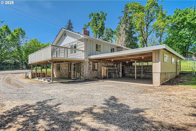 819 Oak St, Silverton, OR 97381 - exterior space with fence, a wooden deck, a carport, a chimney, and board and batten siding