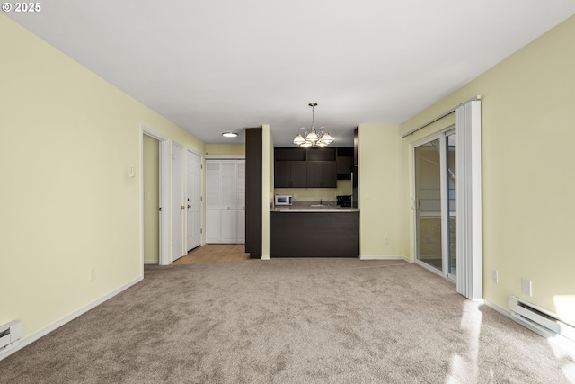 unfurnished living room featuring baseboard heating, light carpet, and an inviting chandelier