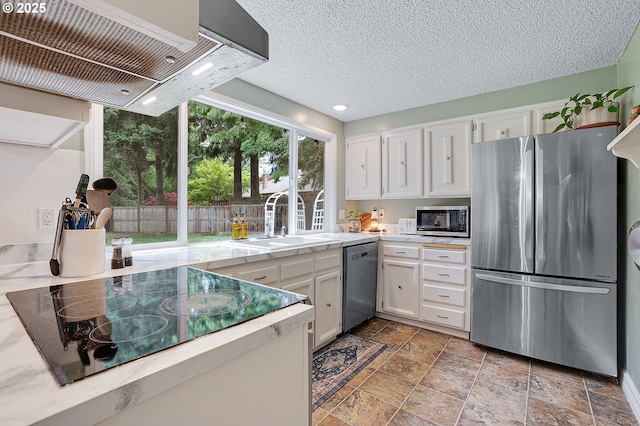 1354 Mulligan Ct, Salem, OR 97306 - kitchen with stainless steel appliances, a sink, light countertops, ventilation hood, and white cabinetry