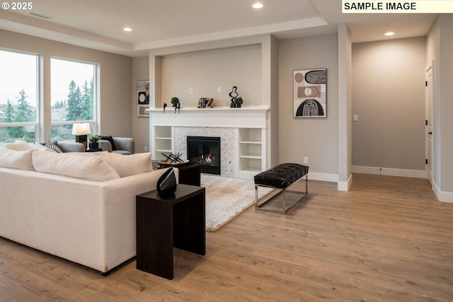 living room with a fireplace, baseboards, wood finished floors, and recessed lighting