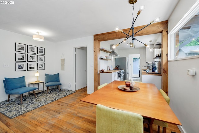 9014 N John Ave, Portland, OR 97203 - dining space with light wood-style flooring, a chandelier, and baseboards