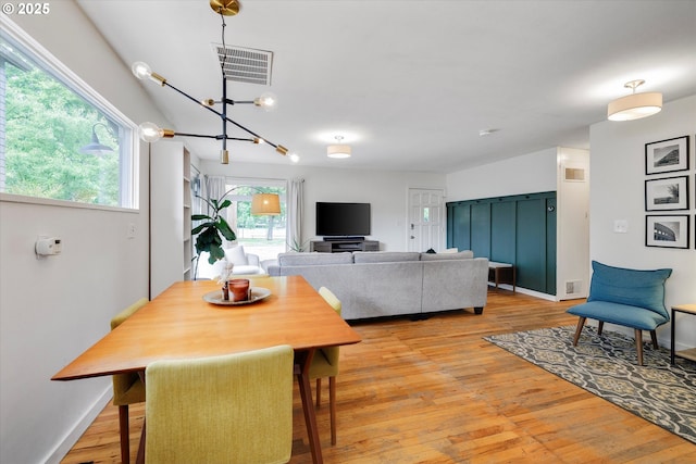 9014 N John Ave, Portland, OR 97203 - dining room with light wood-style flooring, a chandelier, and baseboards