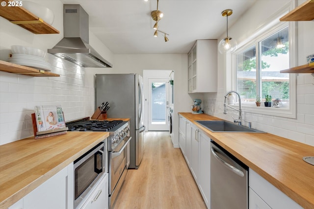 9014 N John Ave, Portland, OR 97203 - kitchen with wooden counters, open shelves, appliances with stainless steel finishes, island range hood, and a sink