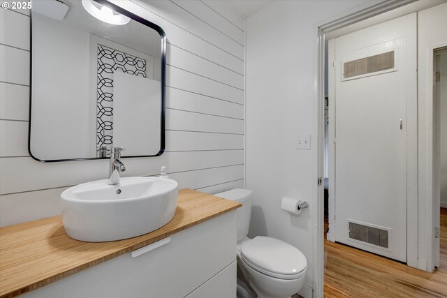 9014 N John Ave, Portland, OR 97203 - bathroom with toilet, vanity, wood finished floors, and wooden walls