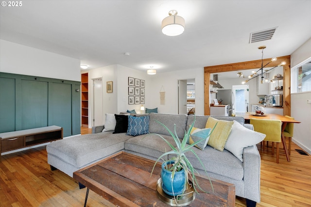 9014 N John Ave, Portland, OR 97203 - living room featuring light wood-style floors and a chandelier