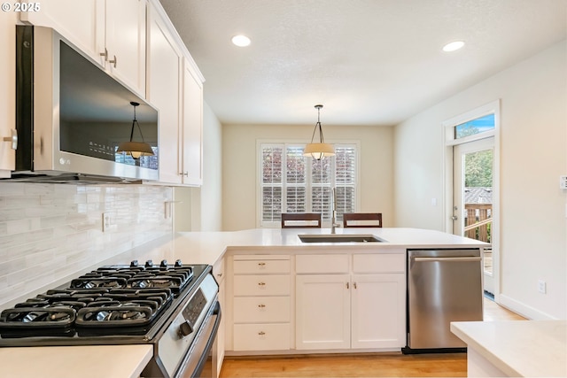2435 NW Burnett St, Portland, OR 97229 - kitchen with appliances with stainless steel finishes, light wood-style floors, backsplash, white cabinets, and light countertops