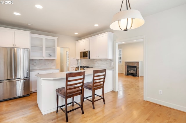 2435 NW Burnett St, Portland, OR 97229 - kitchen with stainless steel appliances, white cabinetry, tasteful backsplash, and recessed lighting