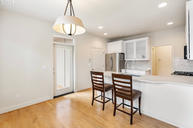 2435 NW Burnett St, Portland, OR 97229 - kitchen featuring stainless steel appliances, backsplash, recessed lighting, light countertops, and glass insert cabinets