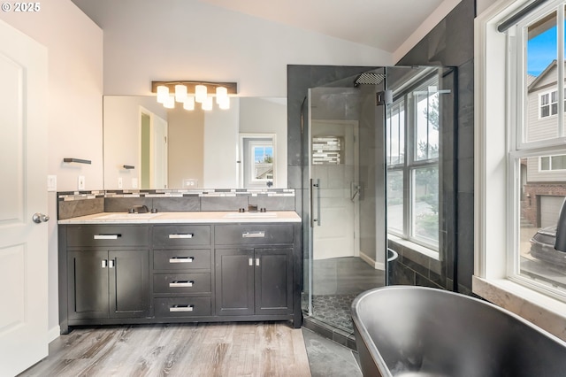 2435 NW Burnett St, Portland, OR 97229 - full bath featuring a shower stall, double vanity, a freestanding tub, wood finished floors, and vaulted ceiling