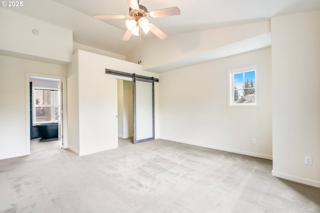 2435 NW Burnett St, Portland, OR 97229 - unfurnished bedroom with light carpet, lofted ceiling, and a barn door