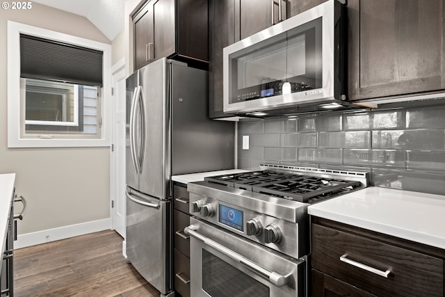 7886 SW Capitol Hill Rd, Portland, OR 97219 - kitchen with appliances with stainless steel finishes, dark brown cabinets, backsplash, wood finished floors, and vaulted ceiling