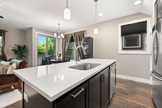 7886 SW Capitol Hill Rd, Portland, OR 97219 - kitchen featuring freestanding refrigerator, a kitchen island with sink, a chandelier, dark wood-type flooring, and light countertops