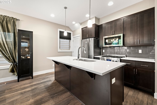 7886 SW Capitol Hill Rd, Portland, OR 97219 - kitchen featuring stainless steel appliances, dark wood-style flooring, a center island with sink, dark brown cabinetry, and light countertops