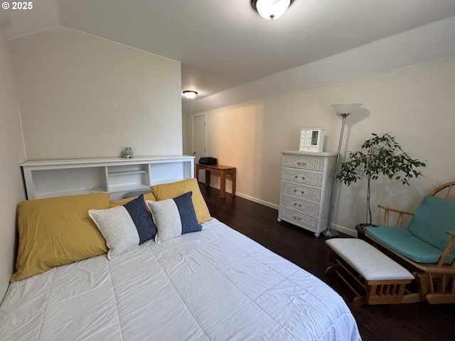 bedroom featuring baseboards, vaulted ceiling, and wood finished floors