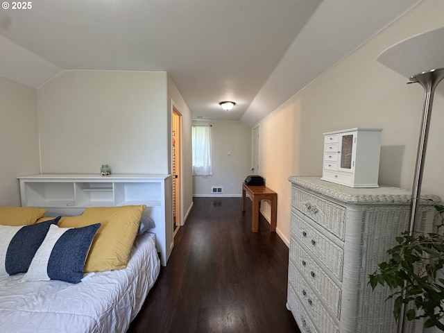 bedroom with dark wood-style flooring, baseboards, visible vents, and lofted ceiling