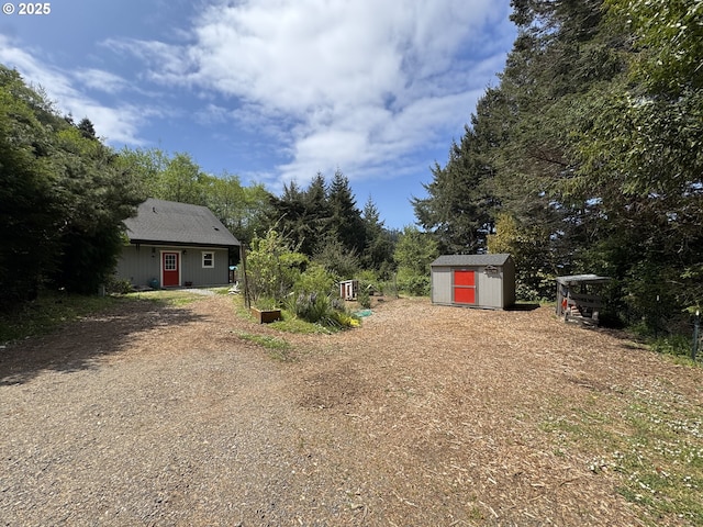 view of yard featuring a storage unit and an outbuilding