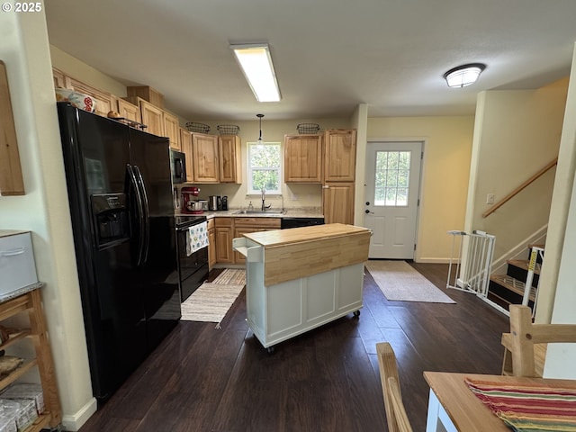 kitchen with dark wood-style flooring, butcher block counters, a center island, a sink, and black appliances