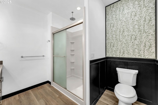 bathroom featuring walk in shower, toilet, and hardwood / wood-style floors