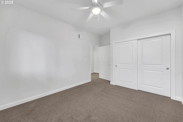 unfurnished bedroom featuring dark carpet, a closet, and ceiling fan