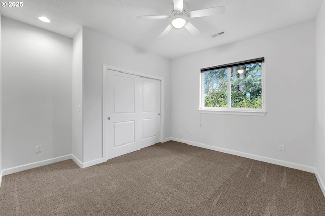 unfurnished bedroom with a closet, ceiling fan, and carpet flooring