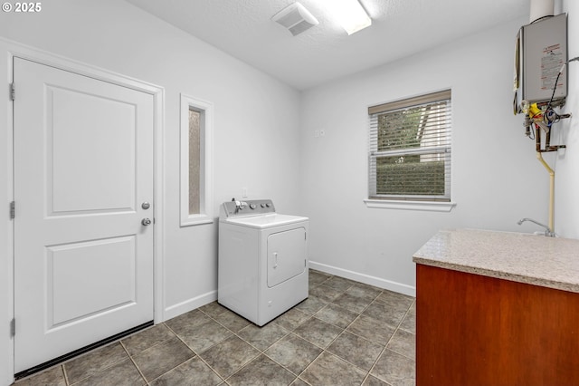 laundry room featuring washer / dryer, a textured ceiling, and dark tile patterned floors