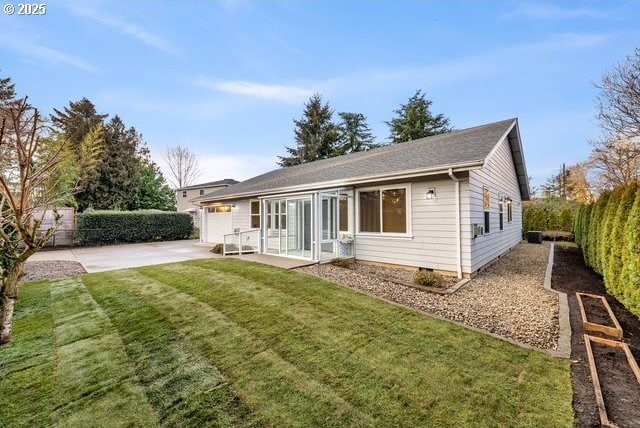 rear view of house with a lawn and a patio area