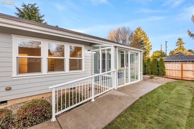 view of property exterior featuring a sunroom and a lawn