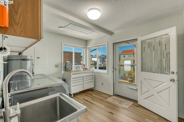 18989 NE Marine Dr Unit 04, Portland, OR 97230 - washroom featuring cabinet space, washer and dryer, a textured ceiling, light wood finished floors, and electric panel