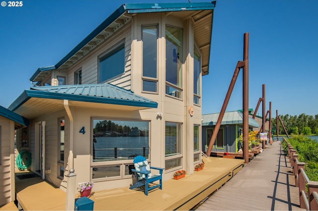18989 NE Marine Dr Unit 04, Portland, OR 97230 - rear view of house featuring metal roof, a wooden deck, and a standing seam roof
