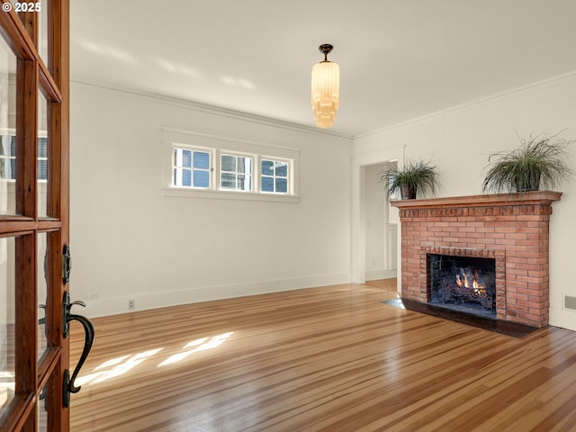 1925 Irving Ave, Astoria, OR 97103 - unfurnished living room with wood finished floors, a brick fireplace, and crown molding