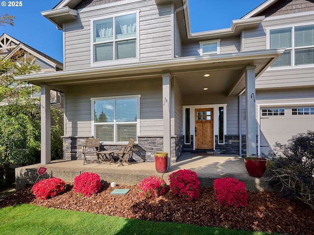 doorway to property with a porch and stone siding