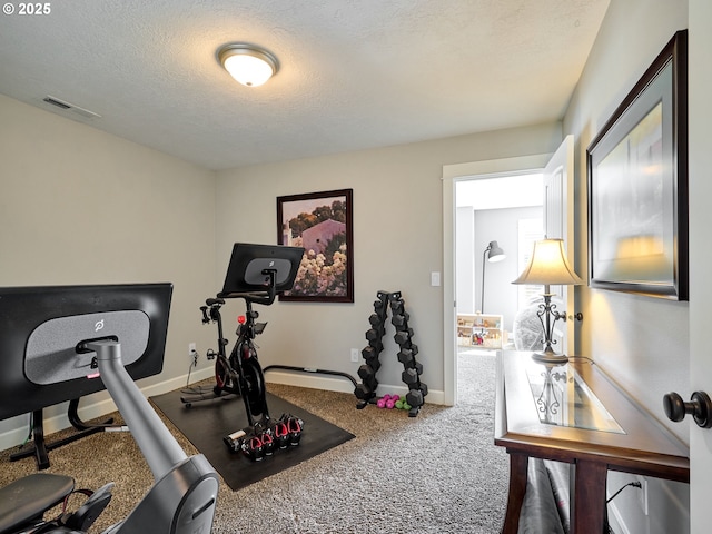 exercise room featuring a textured ceiling, baseboards, visible vents, and carpet