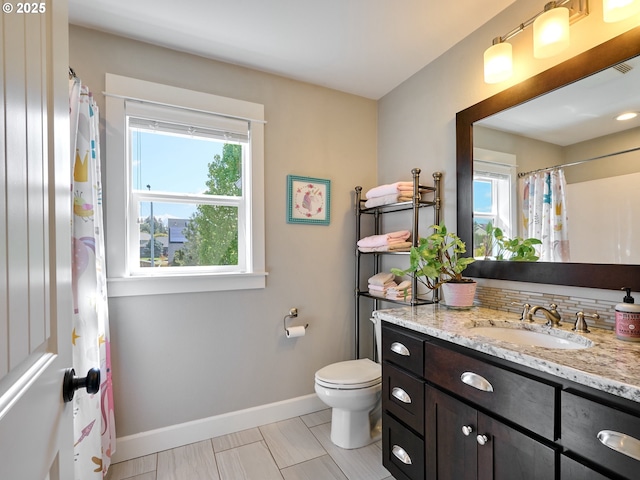 full bathroom with baseboards, toilet, and vanity