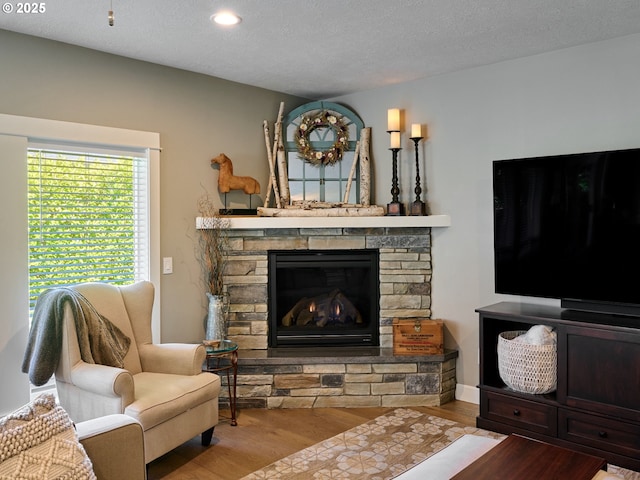 living room with a textured ceiling, a fireplace, recessed lighting, and wood finished floors