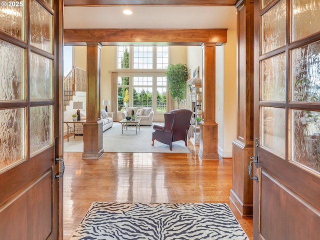 foyer featuring decorative columns and light wood-type flooring