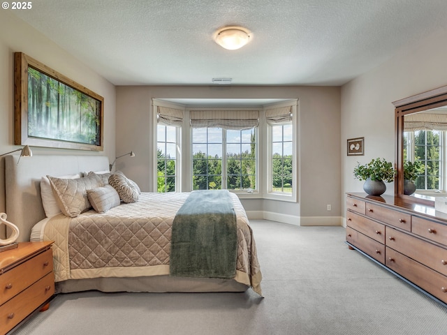 bedroom with light carpet and a textured ceiling