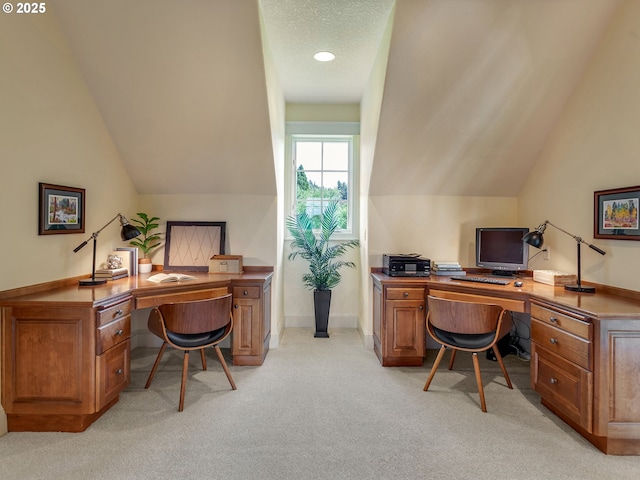 carpeted home office featuring vaulted ceiling and a textured ceiling