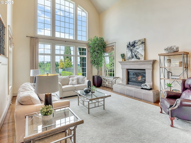 living room featuring a tiled fireplace and a towering ceiling