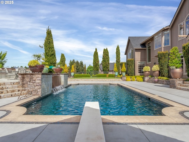 view of pool featuring a patio, a diving board, and pool water feature