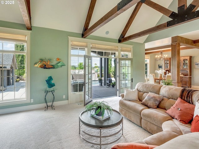 living room with high vaulted ceiling, carpet floors, a notable chandelier, beamed ceiling, and a healthy amount of sunlight