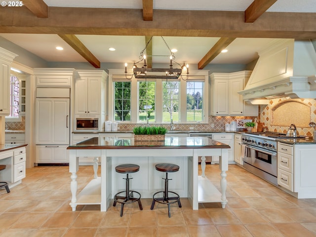 kitchen featuring decorative backsplash, built in appliances, beam ceiling, and custom exhaust hood