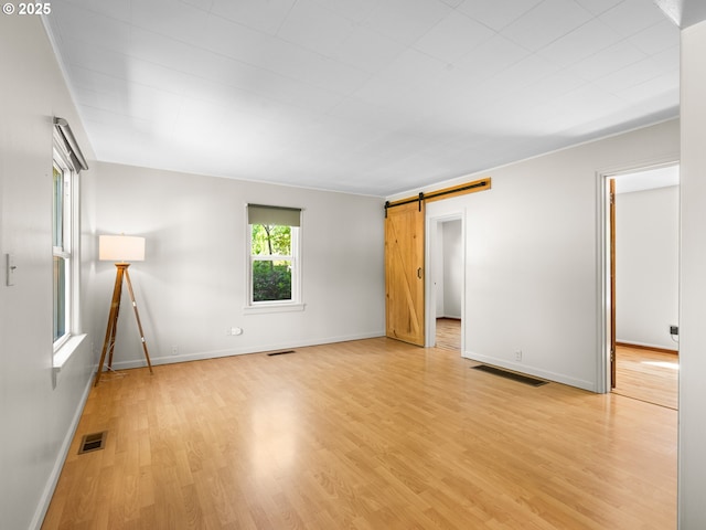 3128 SE 64th Ave, Portland, OR 97206 - unfurnished room with a barn door, light wood-style floors, and baseboards