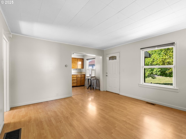 3128 SE 64th Ave, Portland, OR 97206 - unfurnished living room featuring light wood finished floors, baseboards, and crown molding
